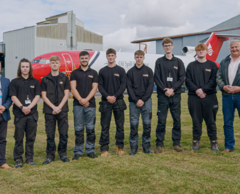 apprentices in black uniform against red and white boeing 727